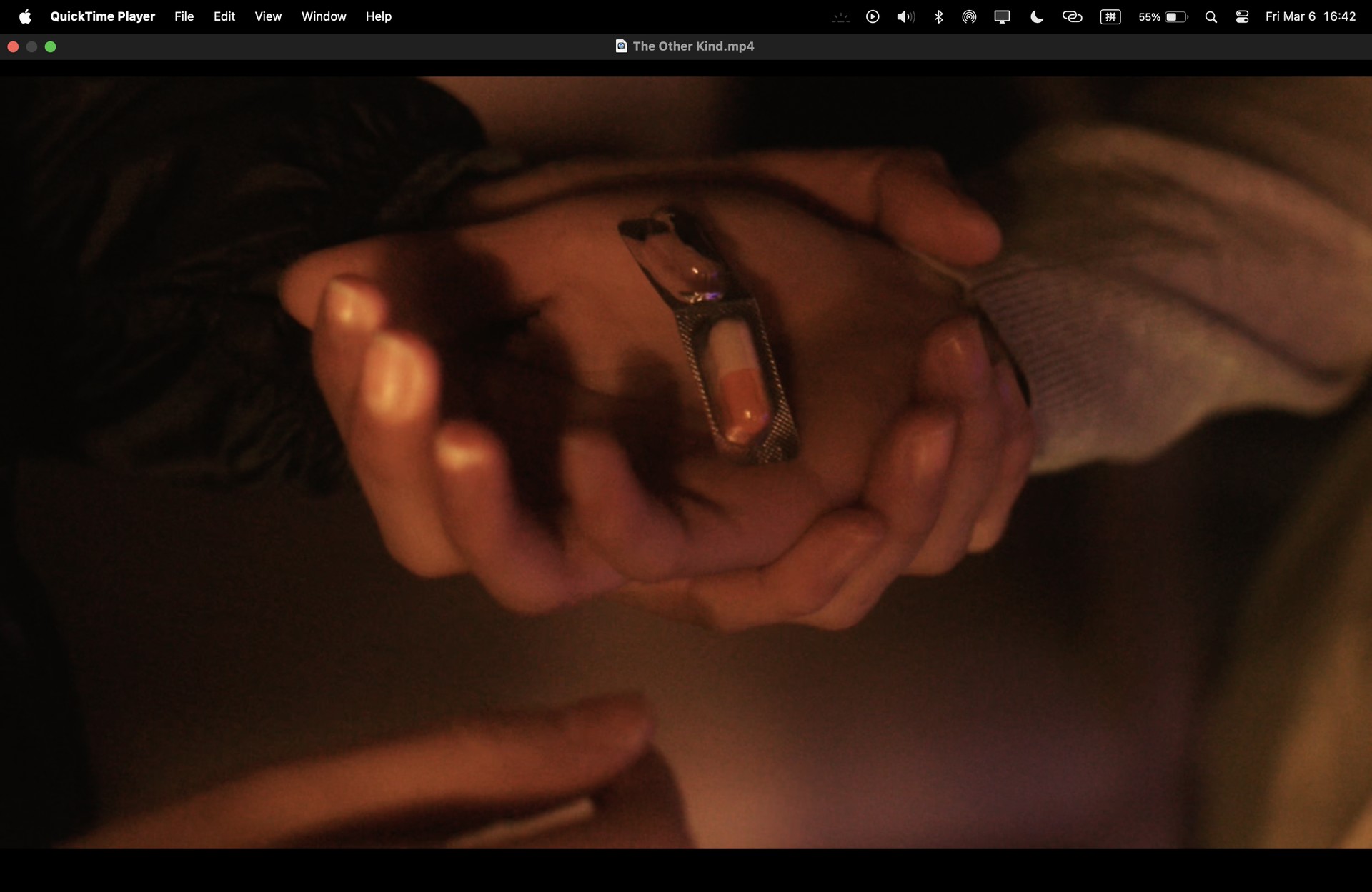 Hands holding medication, with the original player frame