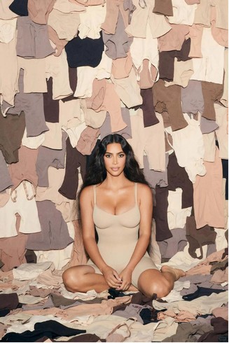 Fashion reference showing a woman seated in a clothing installation